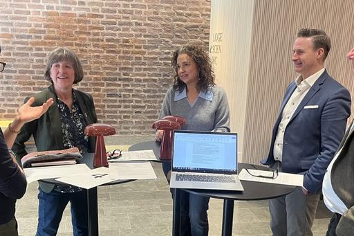Five people standing around a table.